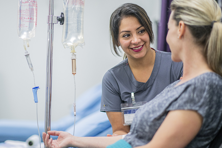 Female Doctor giving intravenous drip treatment to a female patient