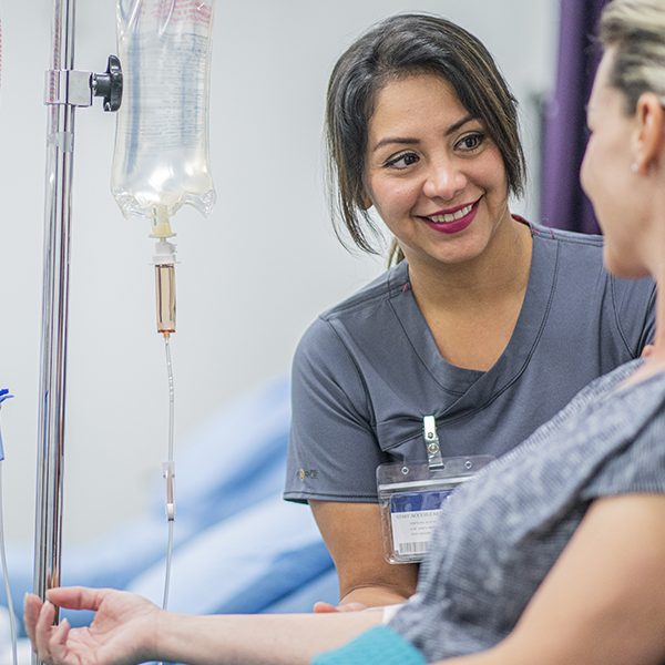 Female Doctor giving intravenous drip treatment to a female patient